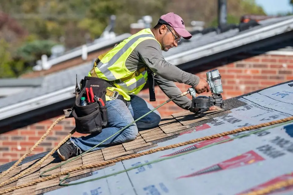 Roofing Companies Huntsville installer nailing architectural shingles on a Huntsville AL home